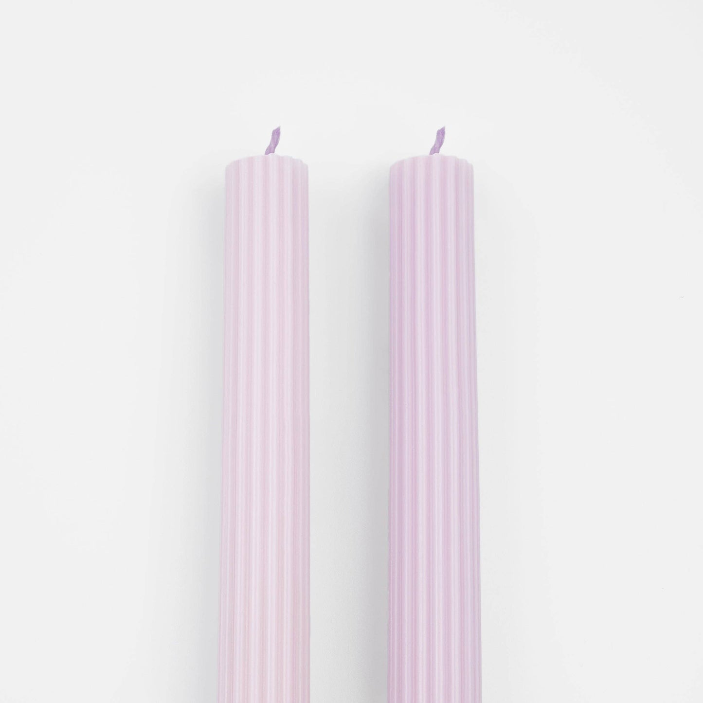 Two pink candles on a white background