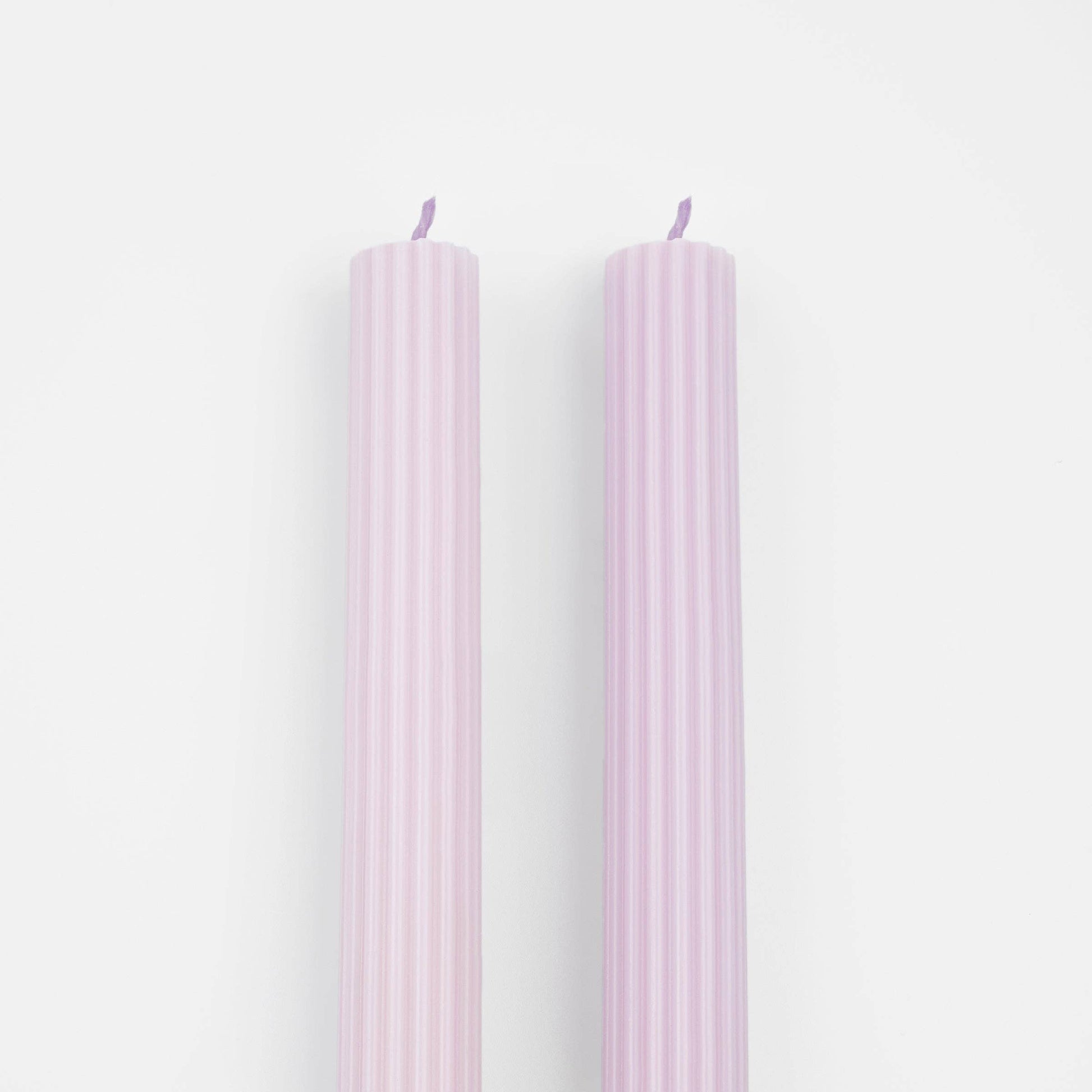 Two pink candles on a white background