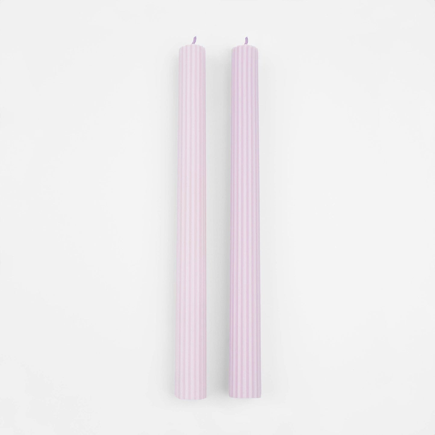 Two pink candles on a white background