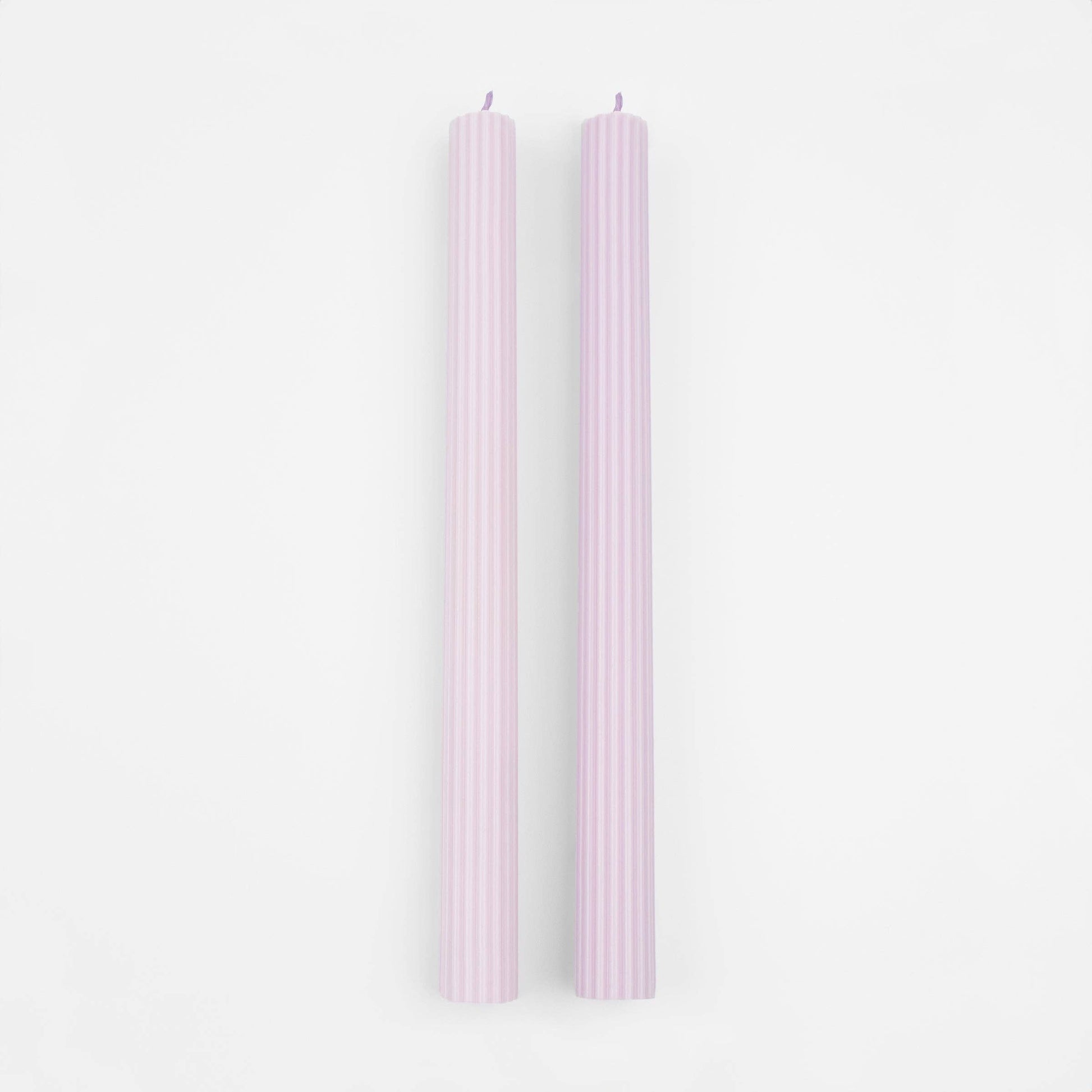 Two pink candles on a white background