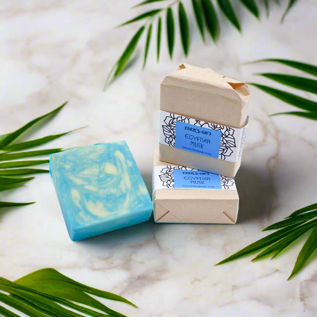 A bar of handmade soap wrapped in brown paper with a blue and white label that reads 'Egyptian Musk'.