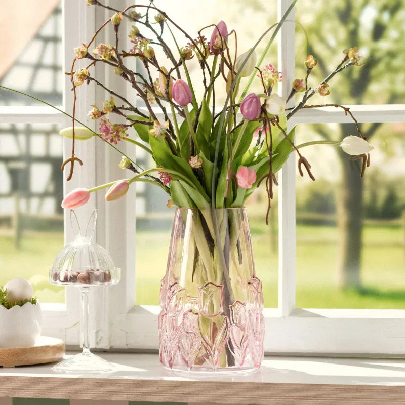 Decorative pink vase with flowers on a windowsill