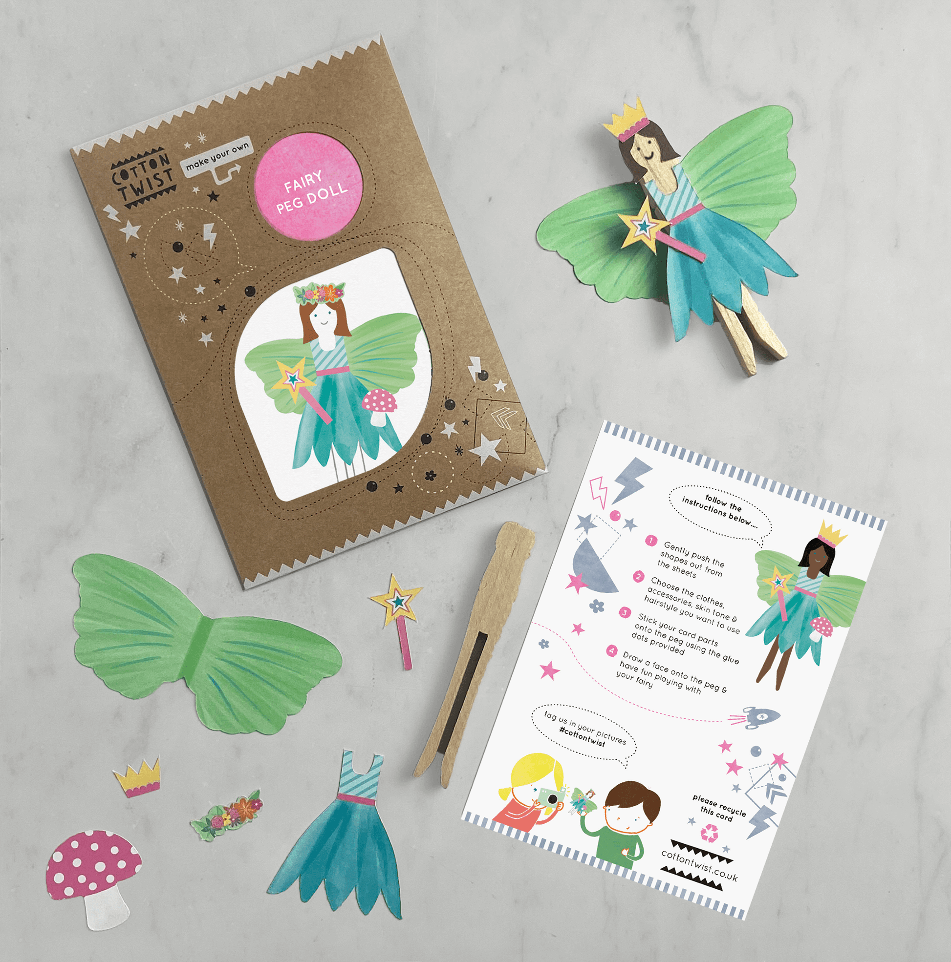 The image shows a fairy peg doll kit, including a cardboard cut-out fairy figure, a wooden peg doll, glue dots, a recyclable kraft envelope, and an A6 printed instruction card.