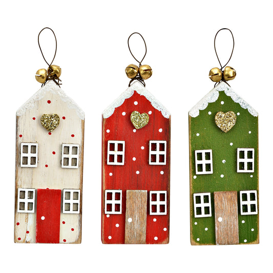 Three wooden house-shaped ornaments in white, red, and green with decorative elements on a white background.