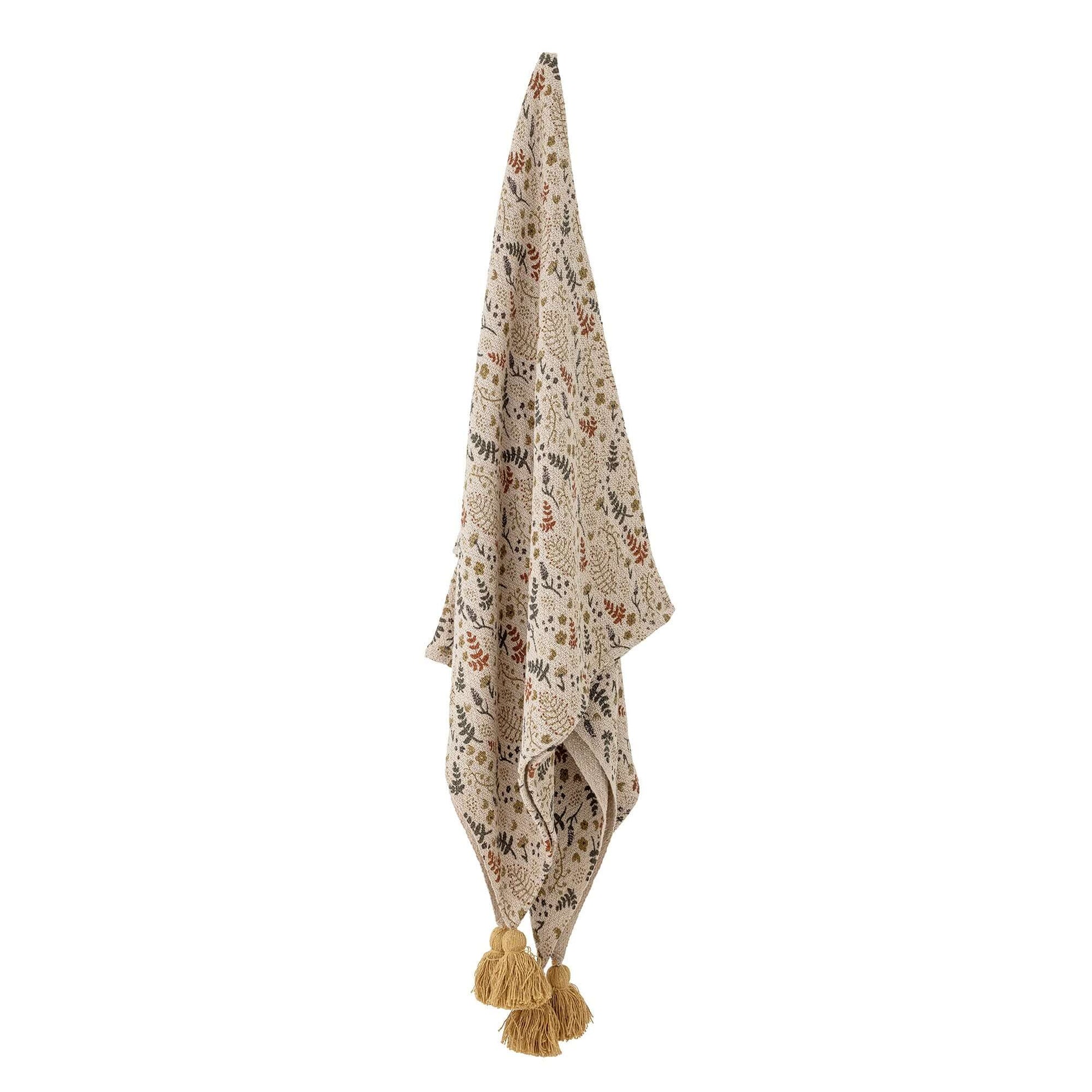 Decorative throw blanket with floral pattern and tassels on a white background