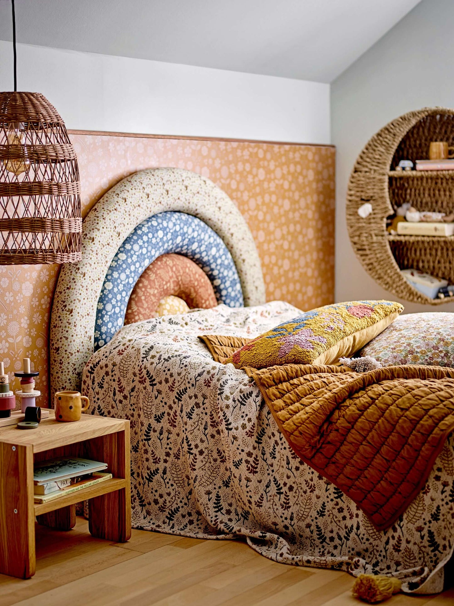 Cozy bedroom with patterned headboard, wooden nightstand, and decorative pillows.