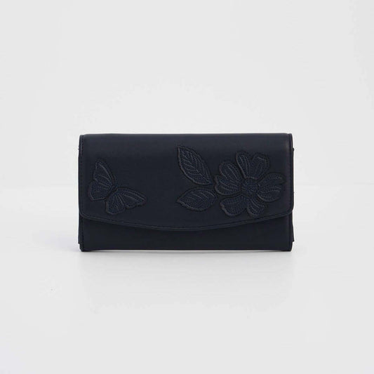 A dark navy blue leather clutch wallet featuring embossed floral and butterfly designs on the front flap, set against a plain light gray background.