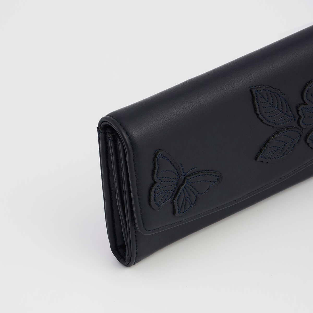 A black leather clutch wallet featuring debossed butterfly and leaf motifs on the front, photographed on a clean white background.