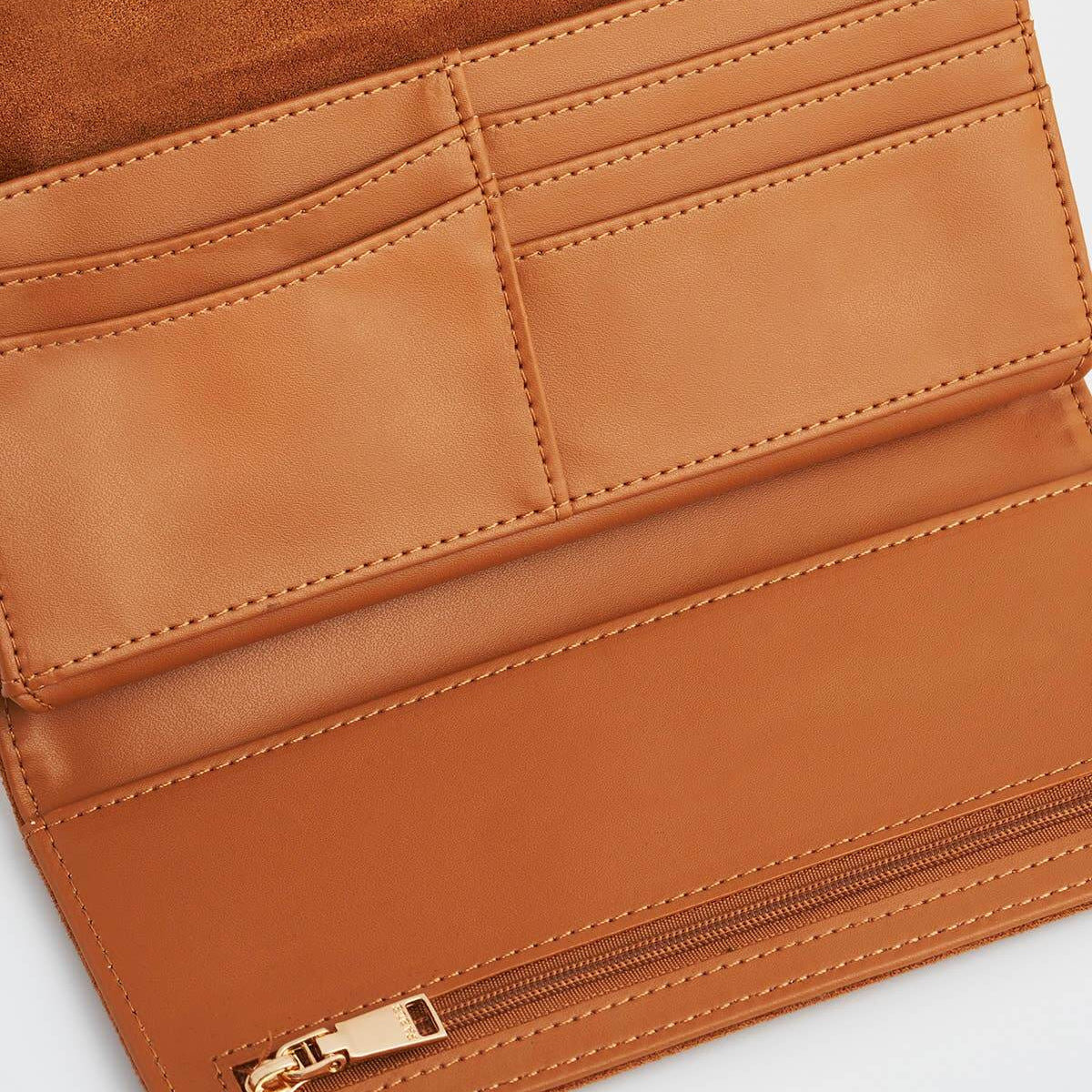 Close-up of a tan wallet with a gold zipper on a white background