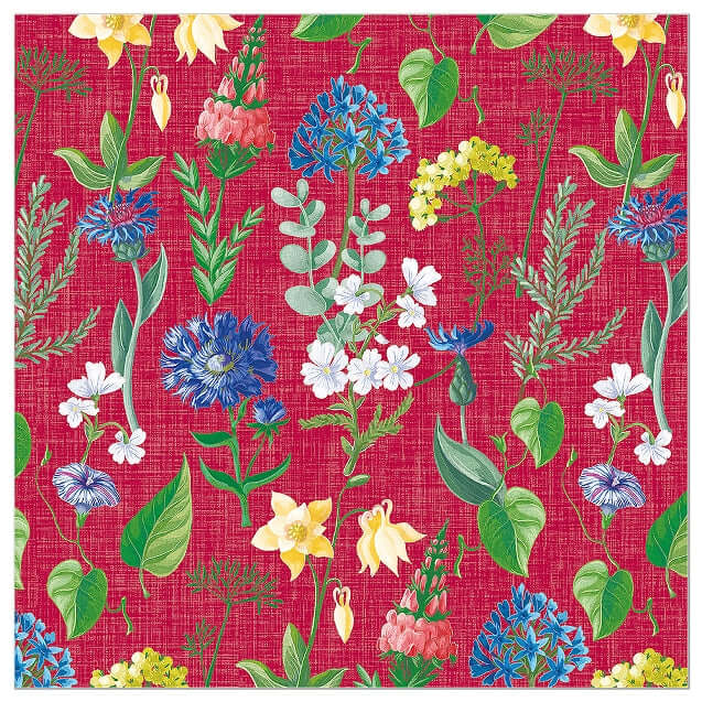A close-up of a woven look print napkin  featuring a repeating floral pattern on a bright pink-red background, with green leaves, blue and white flowers, yellow blossoms, and small pink flowers.