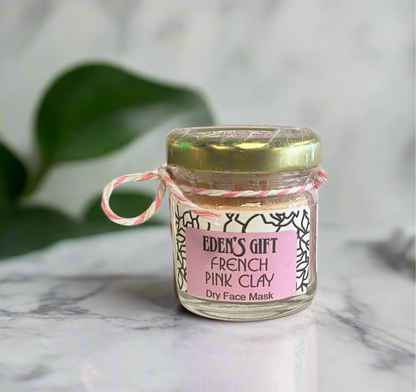 Jar of Eden's Gift French Pink Clay Dry Face Mask on a marble surface with green leaves in the background
