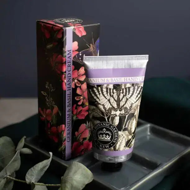 Hand cream and packaging with floral design on a dark surface