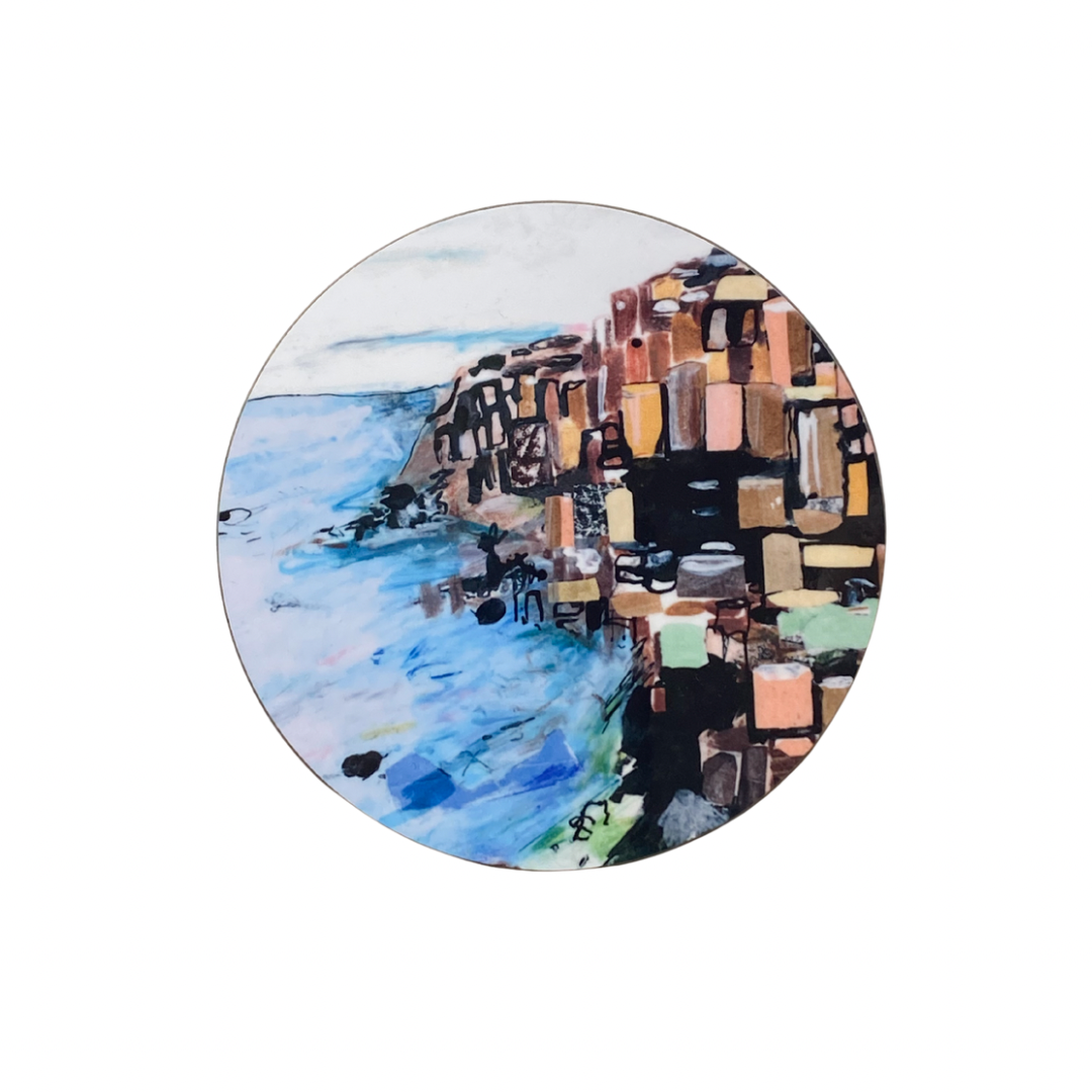 Round coaster with a scenic design of a coastal scene and mosaic pattern.