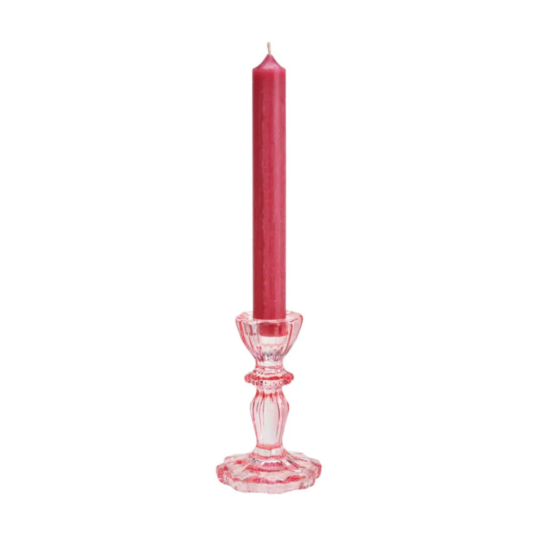 Red candle on a decorative pink candlestick against a white background