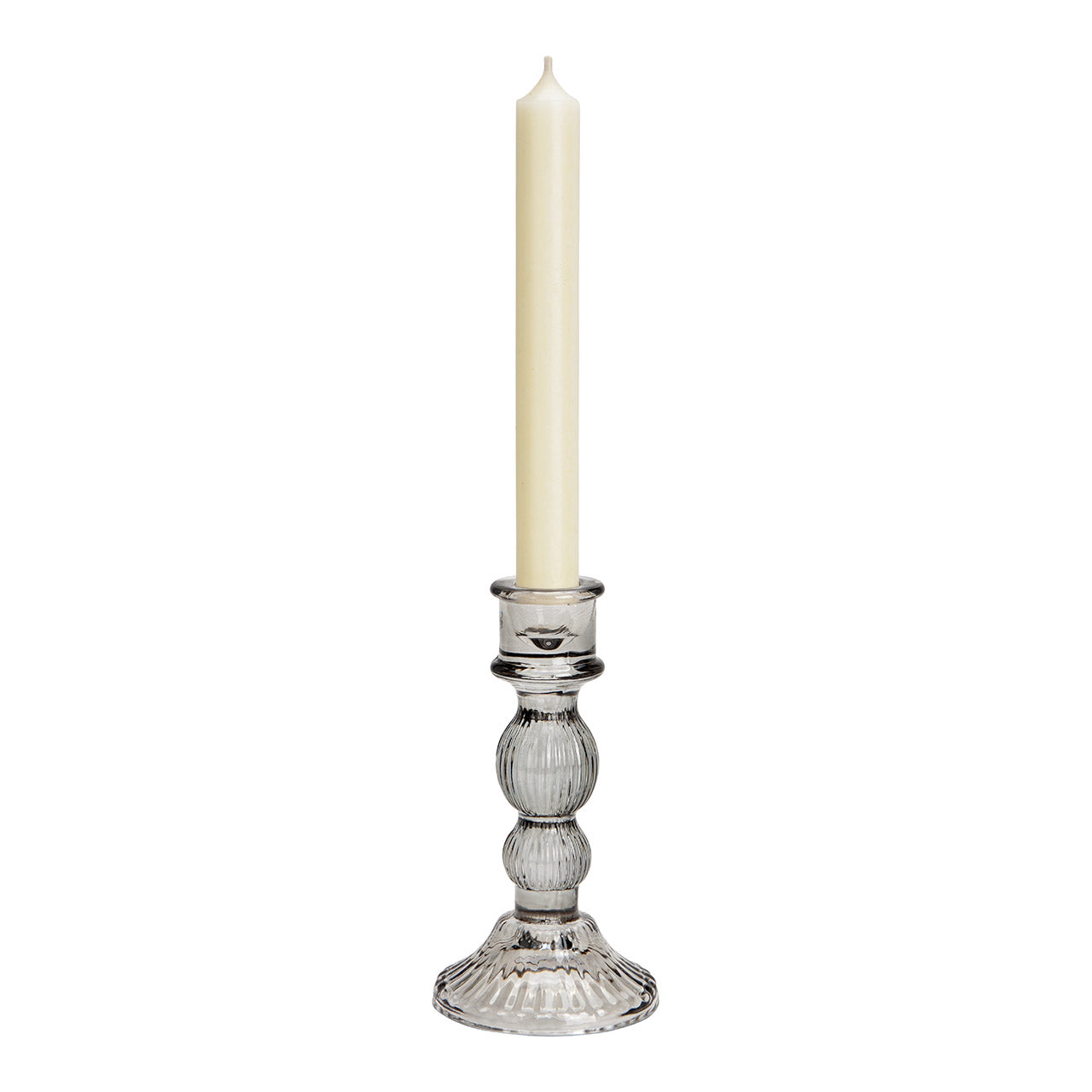 Clear glass candle holder with a white candle on a white background