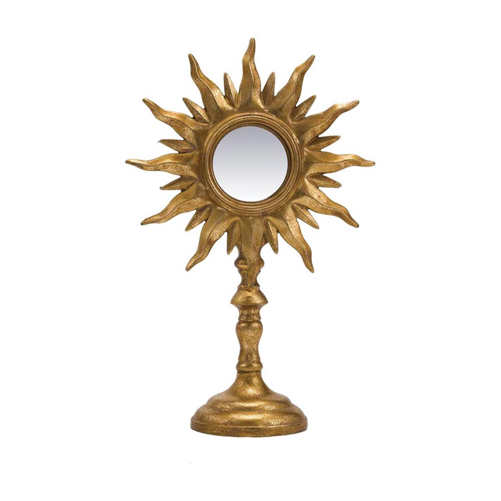 Decorative gold sun-shaped mirror on a white background