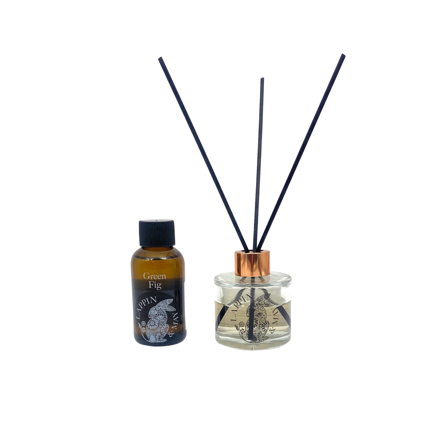 A bottle of Green Fig fragrance oil for diffusers, beside a reed diffuser on a white background