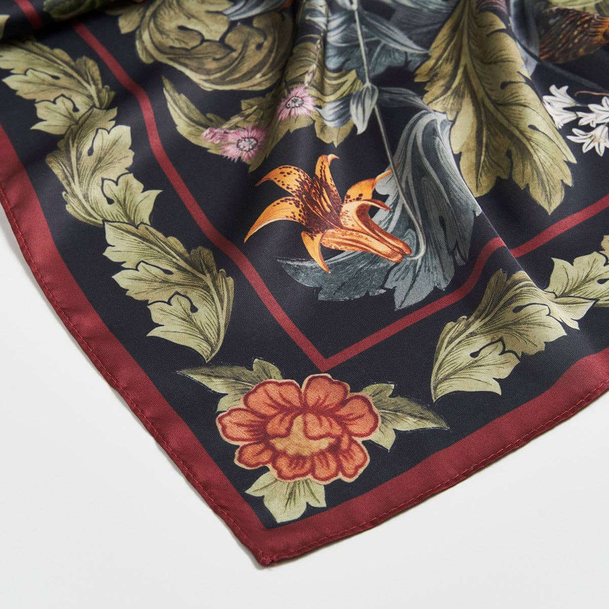 Floral and leaf patterned fabric square on a white background