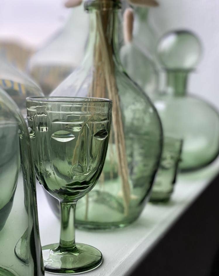 Selection of drinking glassed with face design on a windowsill