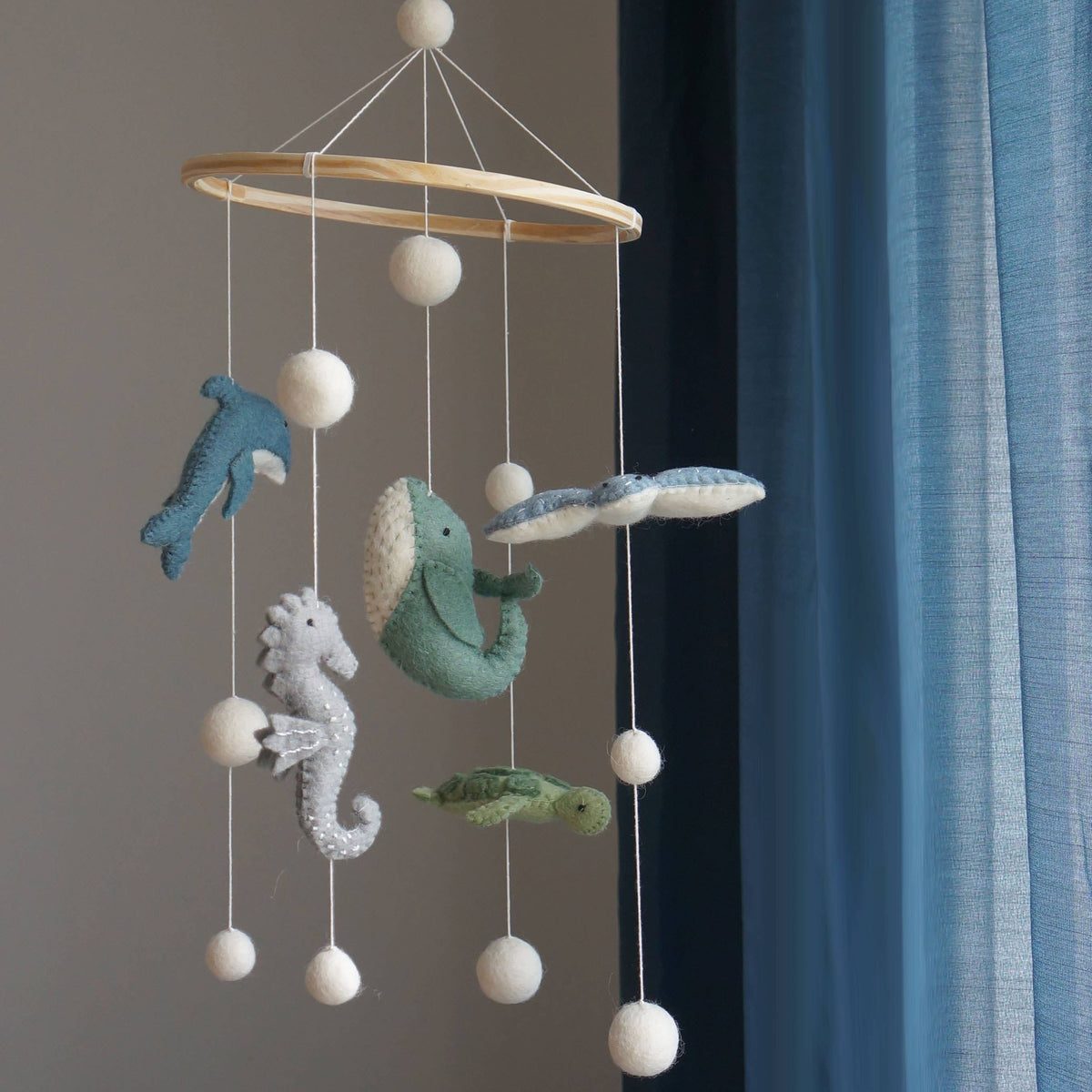 Decorative mobile with sea-themed hanging toys against a neutral background