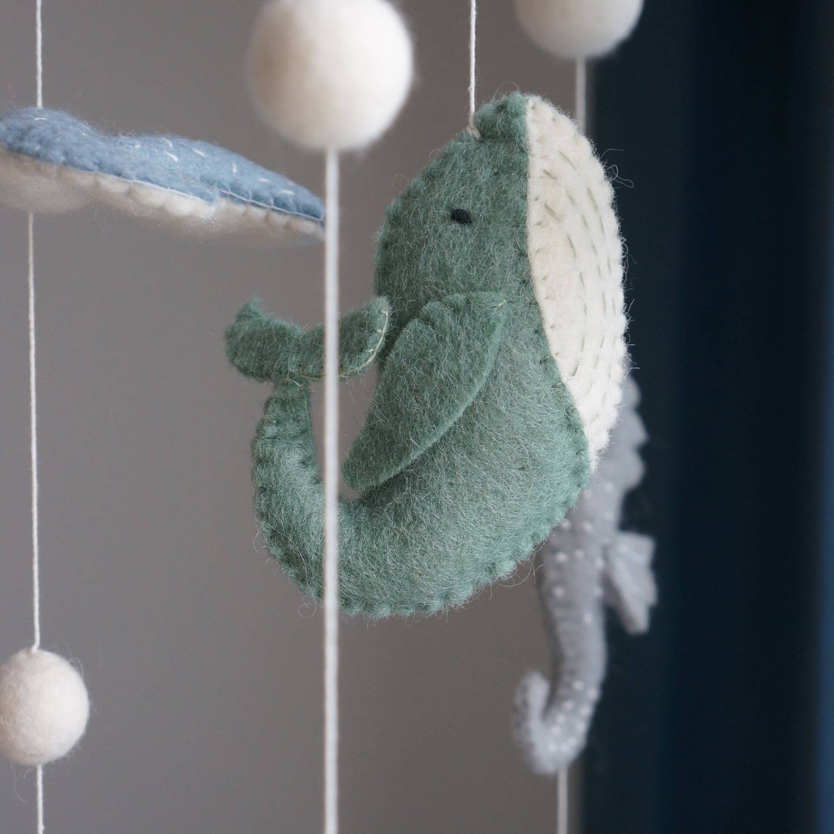 Felt sea creature mobile with a whale and fish on a plain background