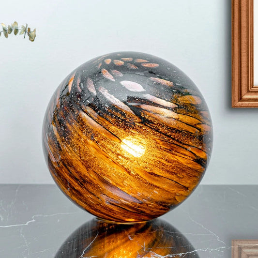 Decorative glass sphere lamp on a table with a light blue wall and framed picture in the background