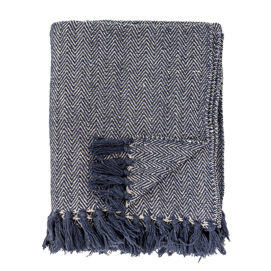 Textured blanket with herringbone pattern and tassels on a white background