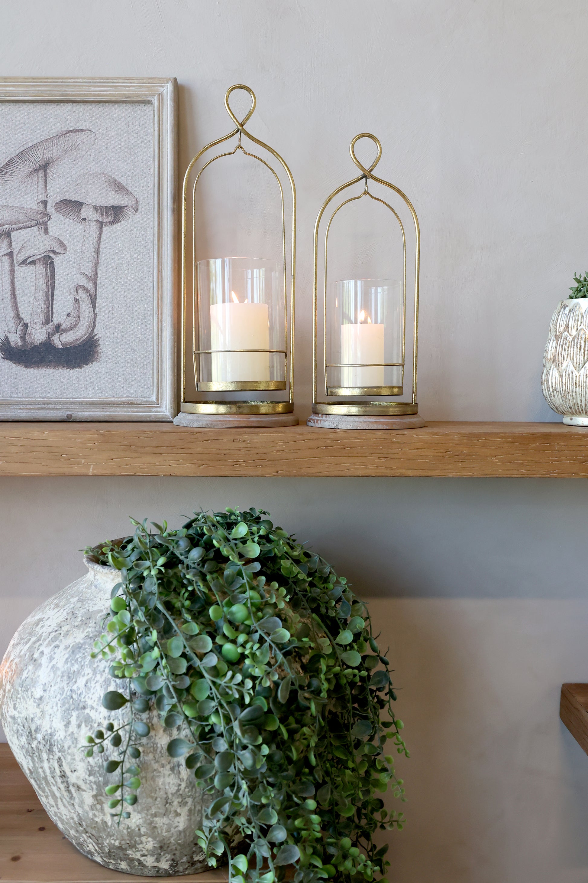 Tall metal and glass hurricane lamps on mantlepiece
