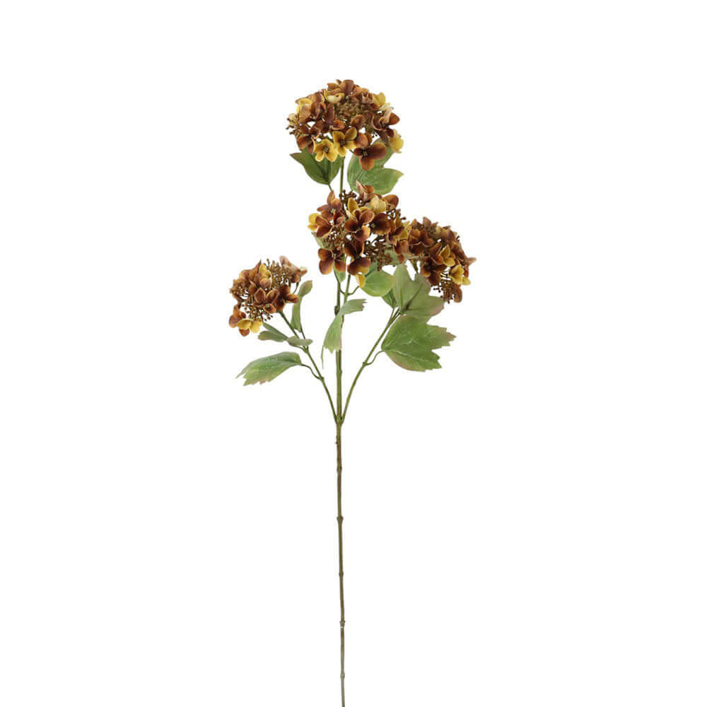An artificial flower stem featuring three clusters of brown and yellow faux blossoms with green leaves on a long brown stem, isolated on a white background.