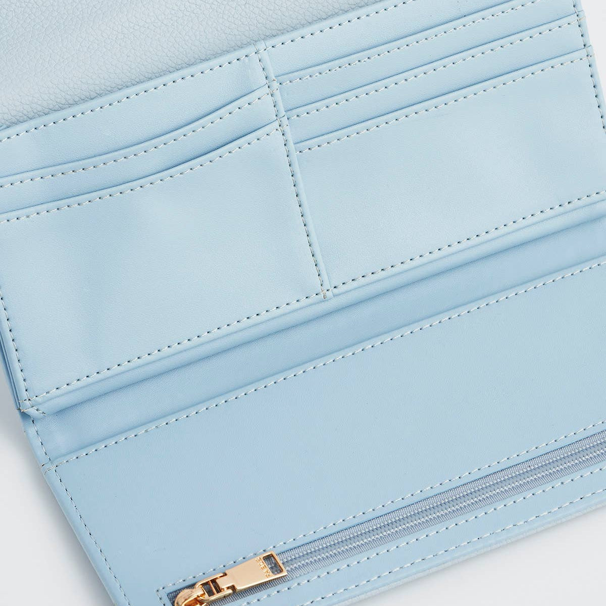 Close-up of a light blue wallet with a gold zipper on a white background