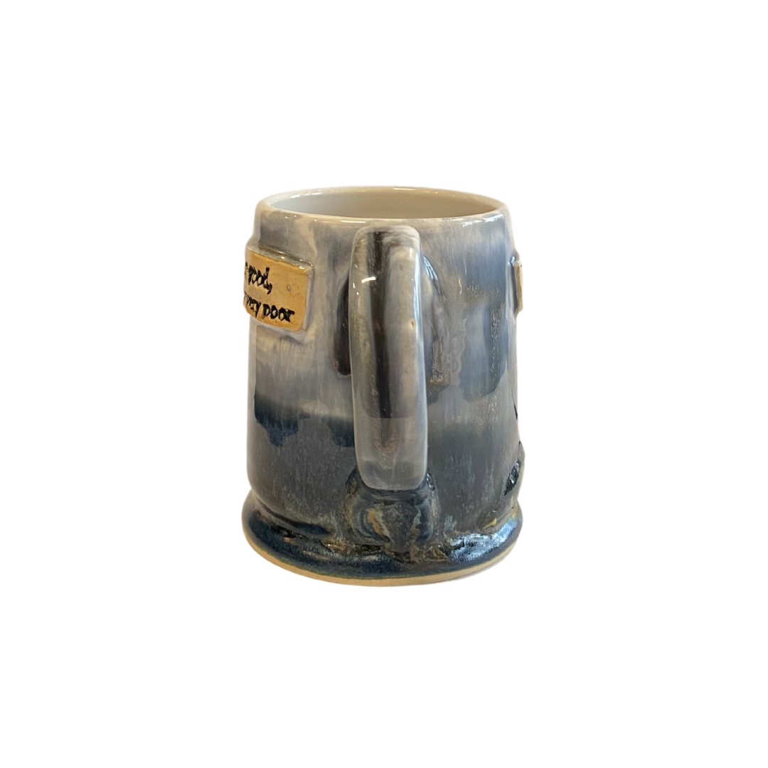 Ceramic mug with blue glaze and a small label on a white background