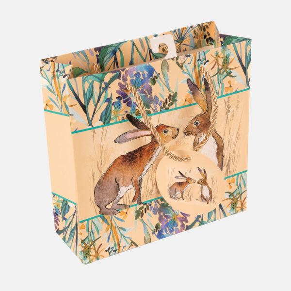 Decorative bag with hares and floral design on a white background