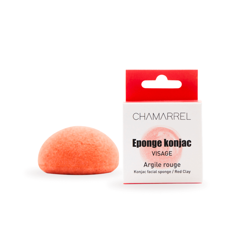 A red clay Konjac Face Sponge next to its packaging, labeled as 'Eponge konjac Visage' with 'Argile rouge' on a white background.