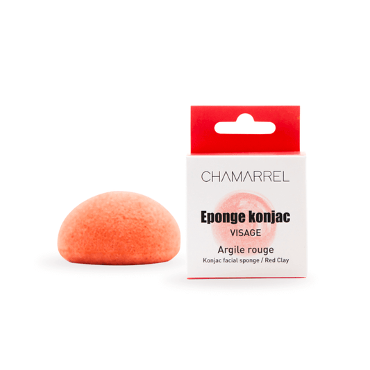 A red clay Konjac Face Sponge next to its packaging, labeled as 'Eponge konjac Visage' with 'Argile rouge' on a white background.