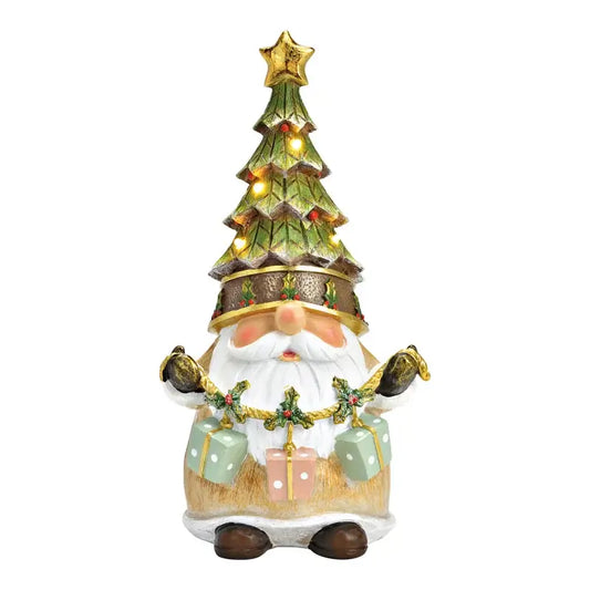 Decorative gnome with a Christmas tree on its head, holding gift boxes, on a white background.