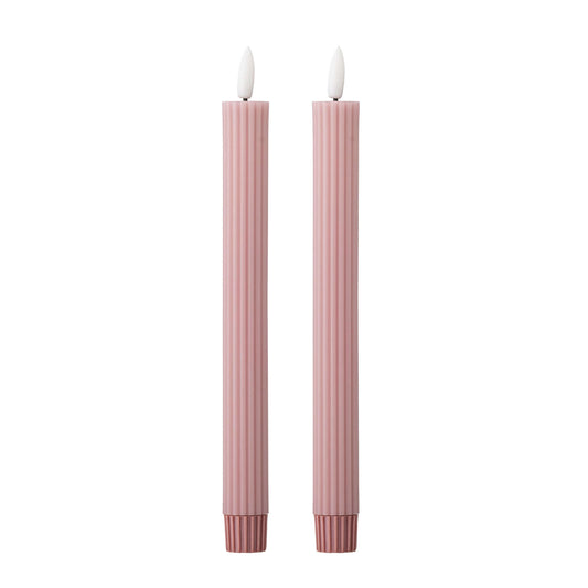 Two tall, thin pink striped candles with white flame-shaped tops, shown side by side on a plain white background.