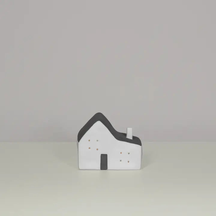 Small model of a house with a gray roof on a light gray background