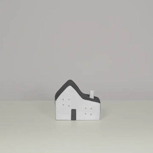 Small model of a house with a gray roof on a light gray background