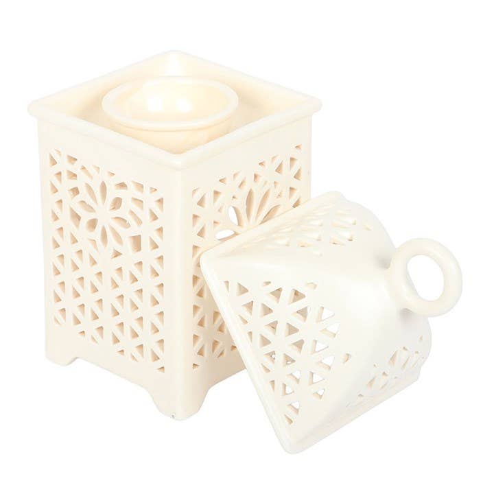 Decorative white lantern with intricate cut-out patterns on a white background