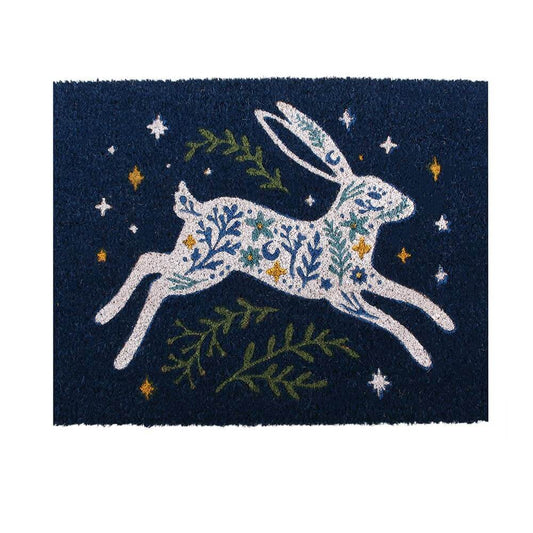 A rectangular dark navy doormat featuring a white hare filled with blue and green floral patterns, surrounded by green leaves and small yellow stars.