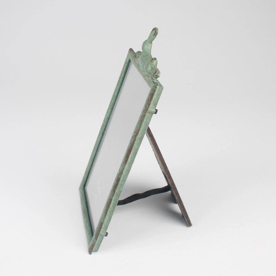 Decorative metal screen with a green patina on a white background