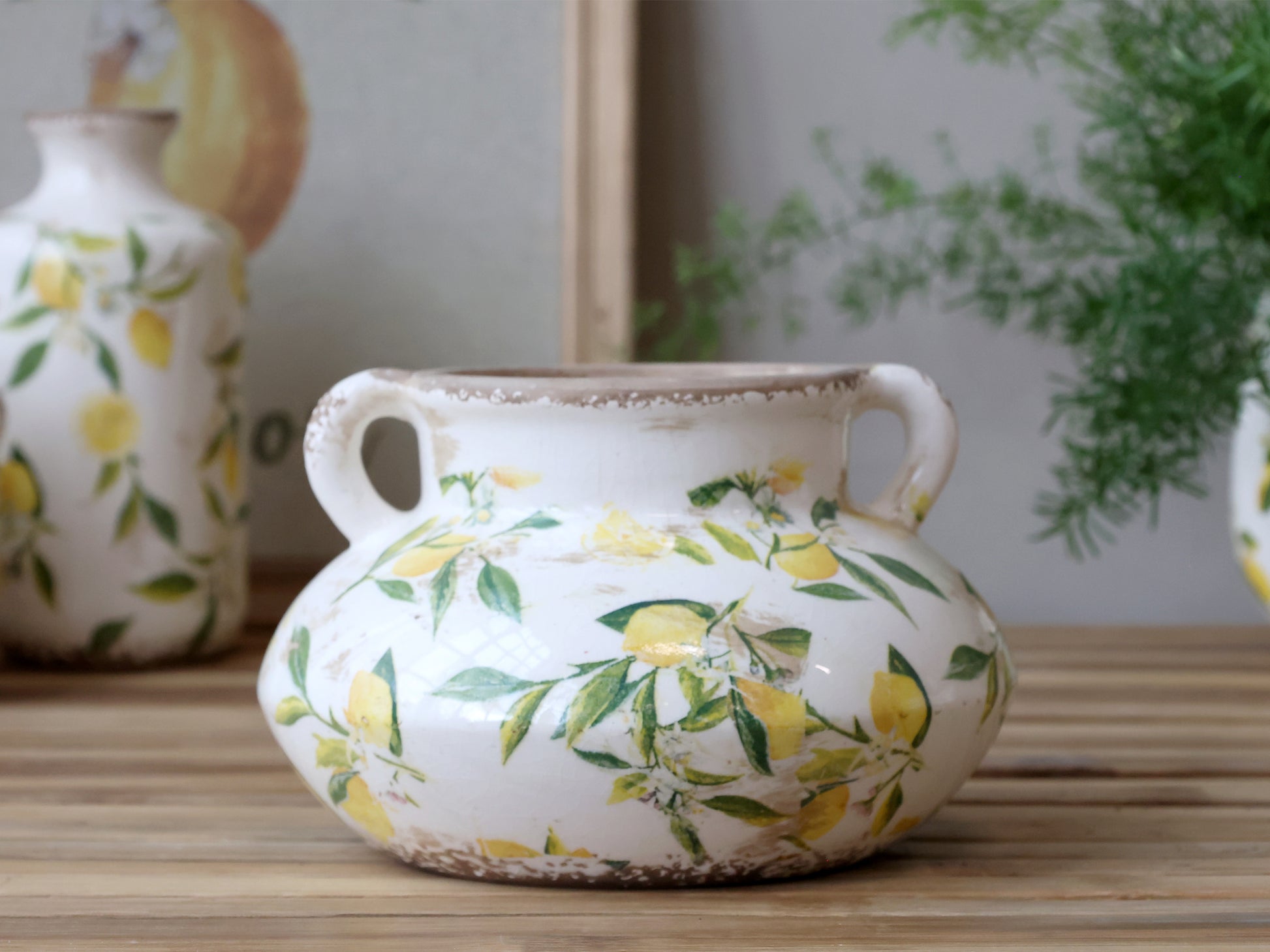 Decorative ceramic pot with lemon design on a wooden surface