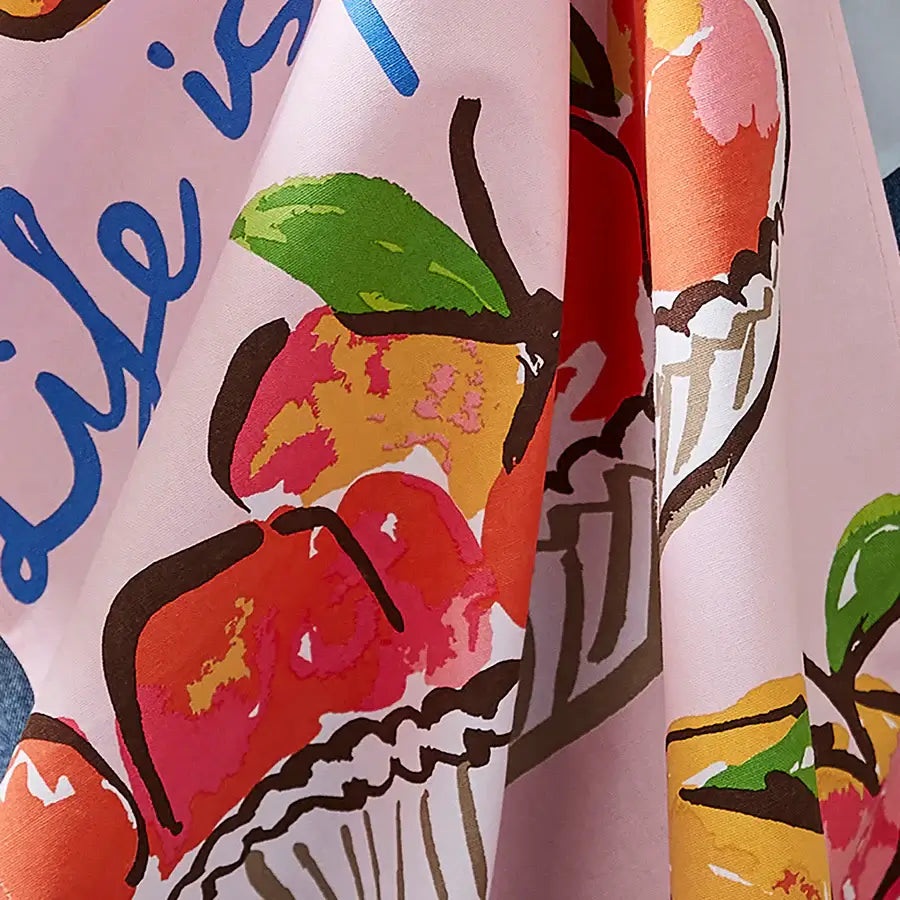 Colorful fabric with abstract fruit design and text on a pink background