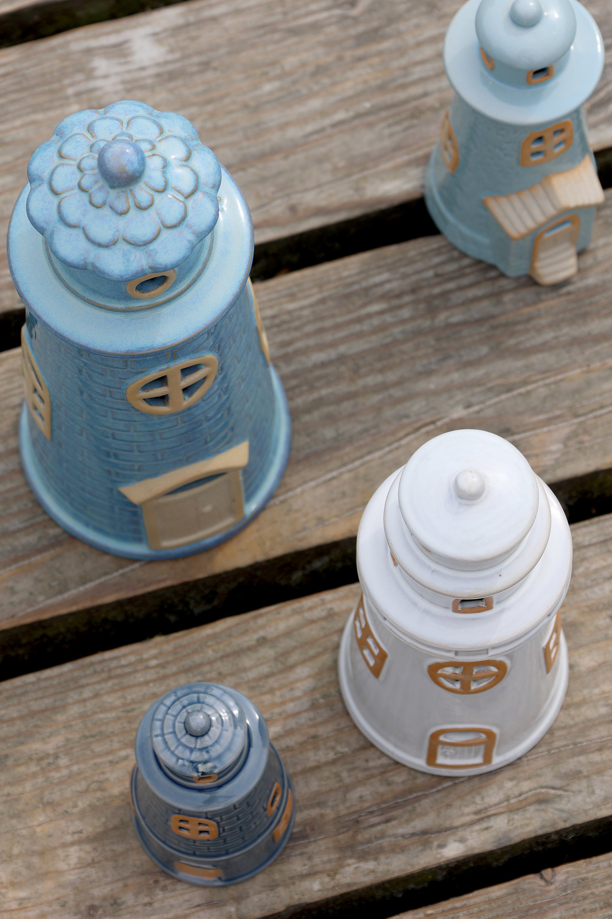 Set of decorative ceramic lighthouses on a wooden surface
