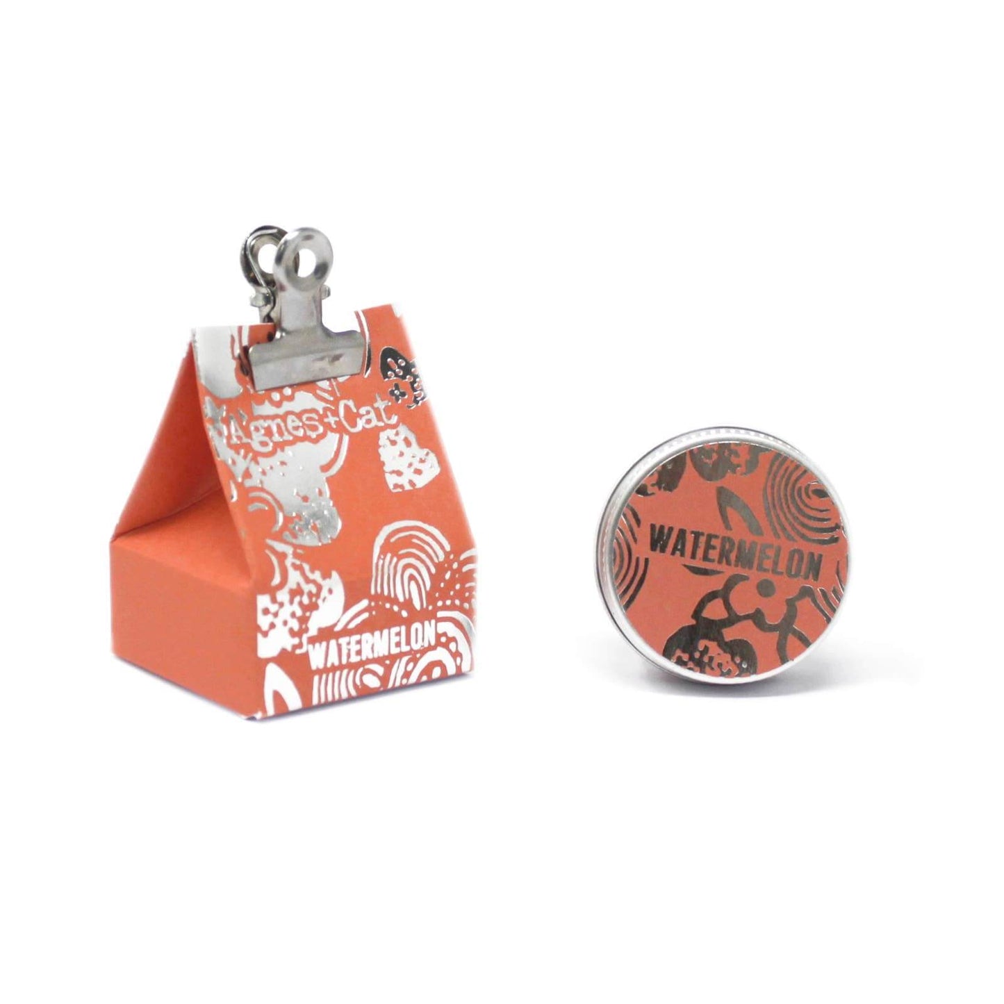 Agnes + Cat lip balm tin beside packaging