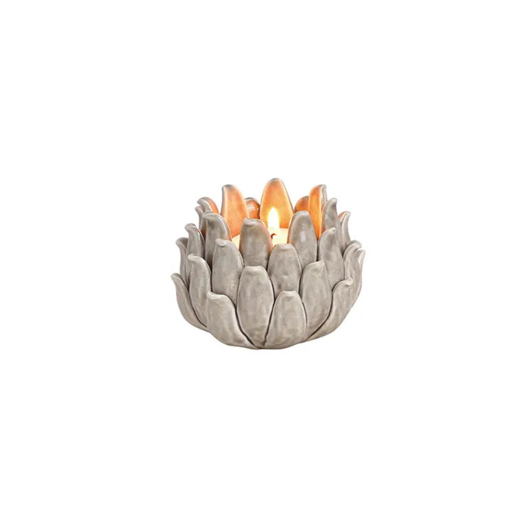 Decorative candle holder with a lit candle on a white background