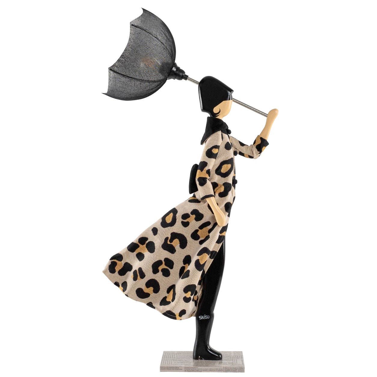 Decorative lamp in the figure of a woman in a leopard print dress holding an umbrella on a white background