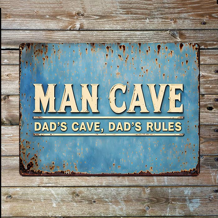 Rustic metal sign with 'Man Cave' text on a wooden background