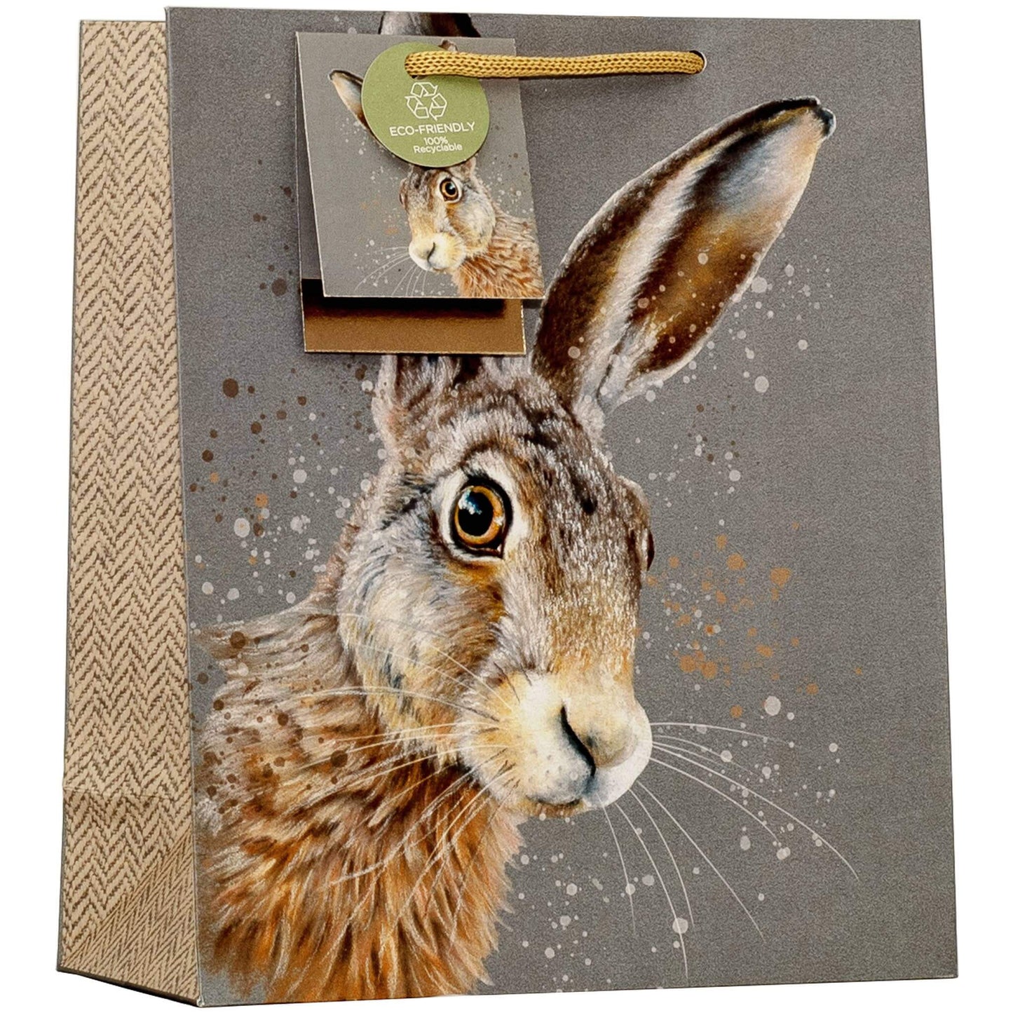 A square gift bag featuring a realistic brown and gray hare illustration on a taupe background, with a burlap-textured side panel, gold handle, and a hanging eco-friendly paper tag showing a small hare photo.