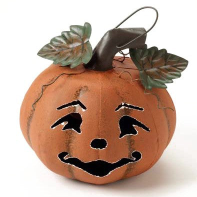 Decorative metal pumpkin with a face on a white background